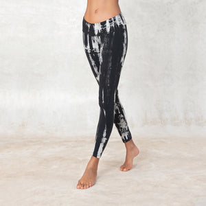 women wearing low waist black and white tie-dye leggings. The leggings are ankle lenght and mae of organic cotton.